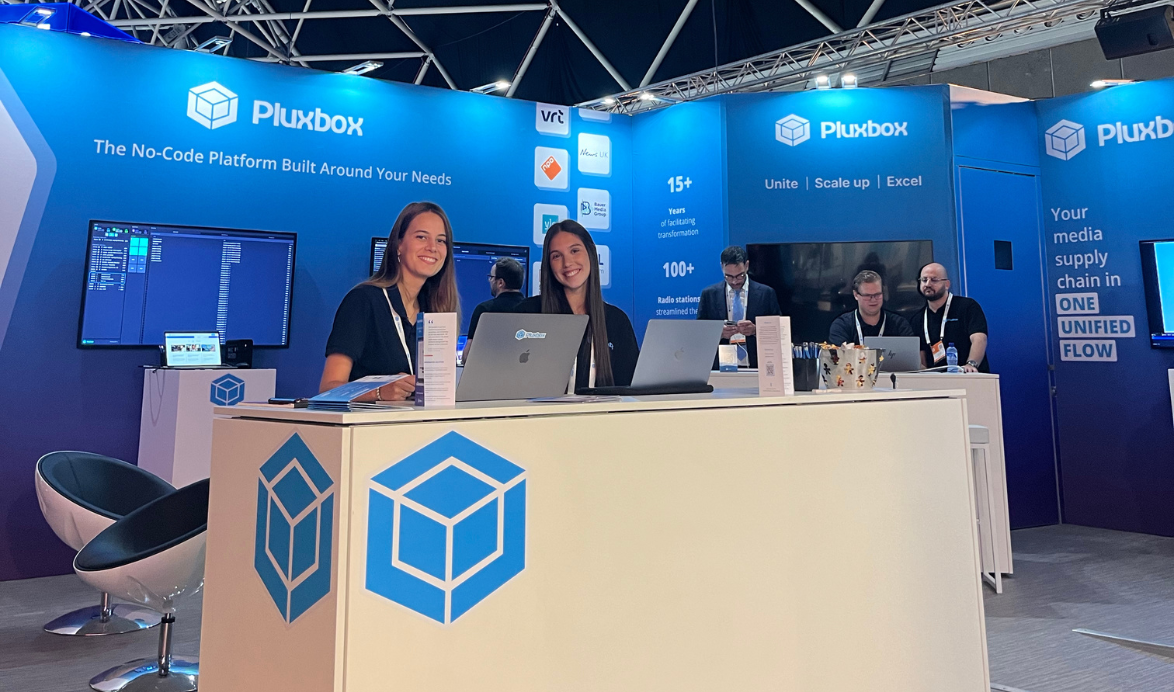 Two Pluxbox employees standing and smiling at the Pluxbox exhibition booth